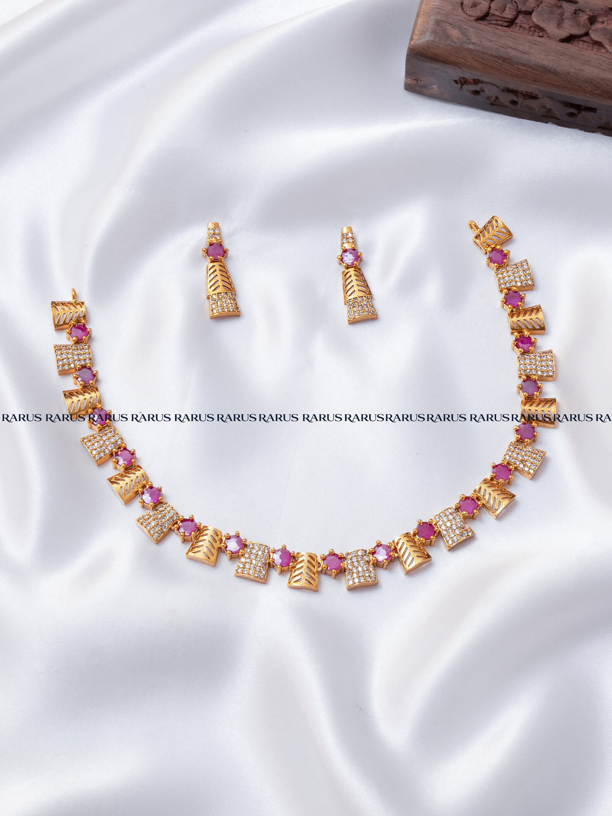 Ruby red leaf motif AD stone necklace set with gold leaf panels and matching earrings, RARUS Jewels